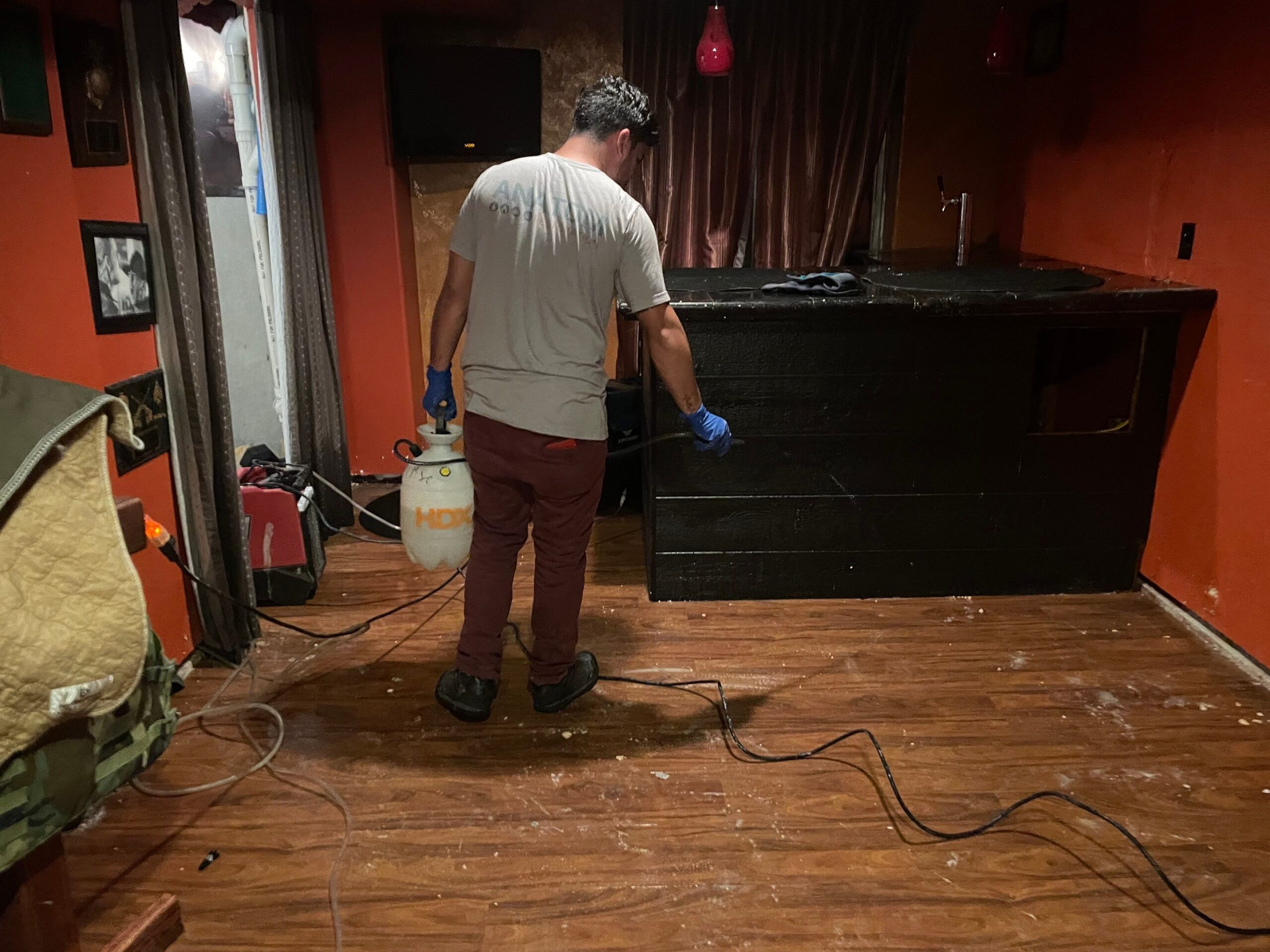 Technician spraying treatment on a damaged floor