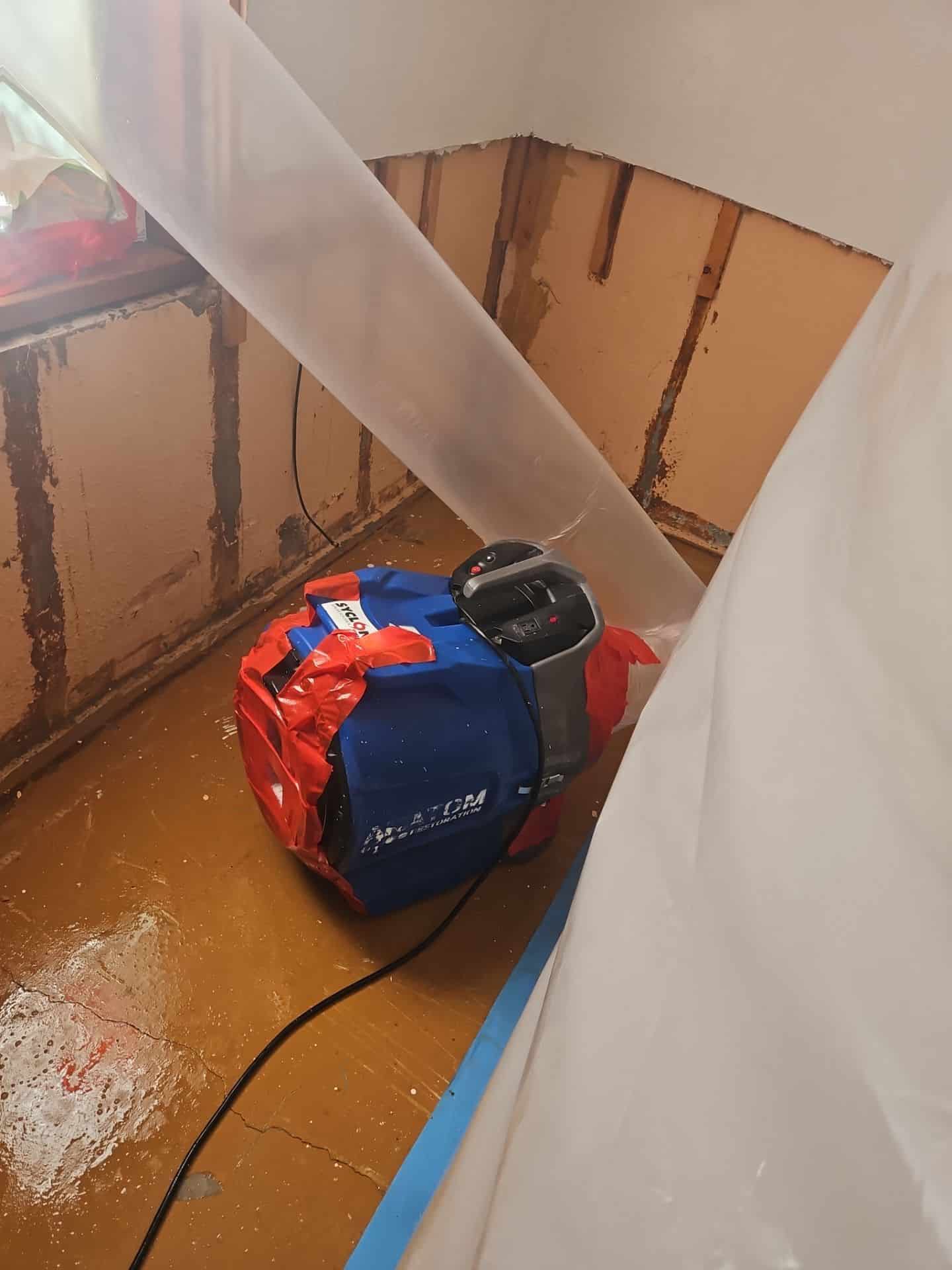Air mover drying a water-damaged room
