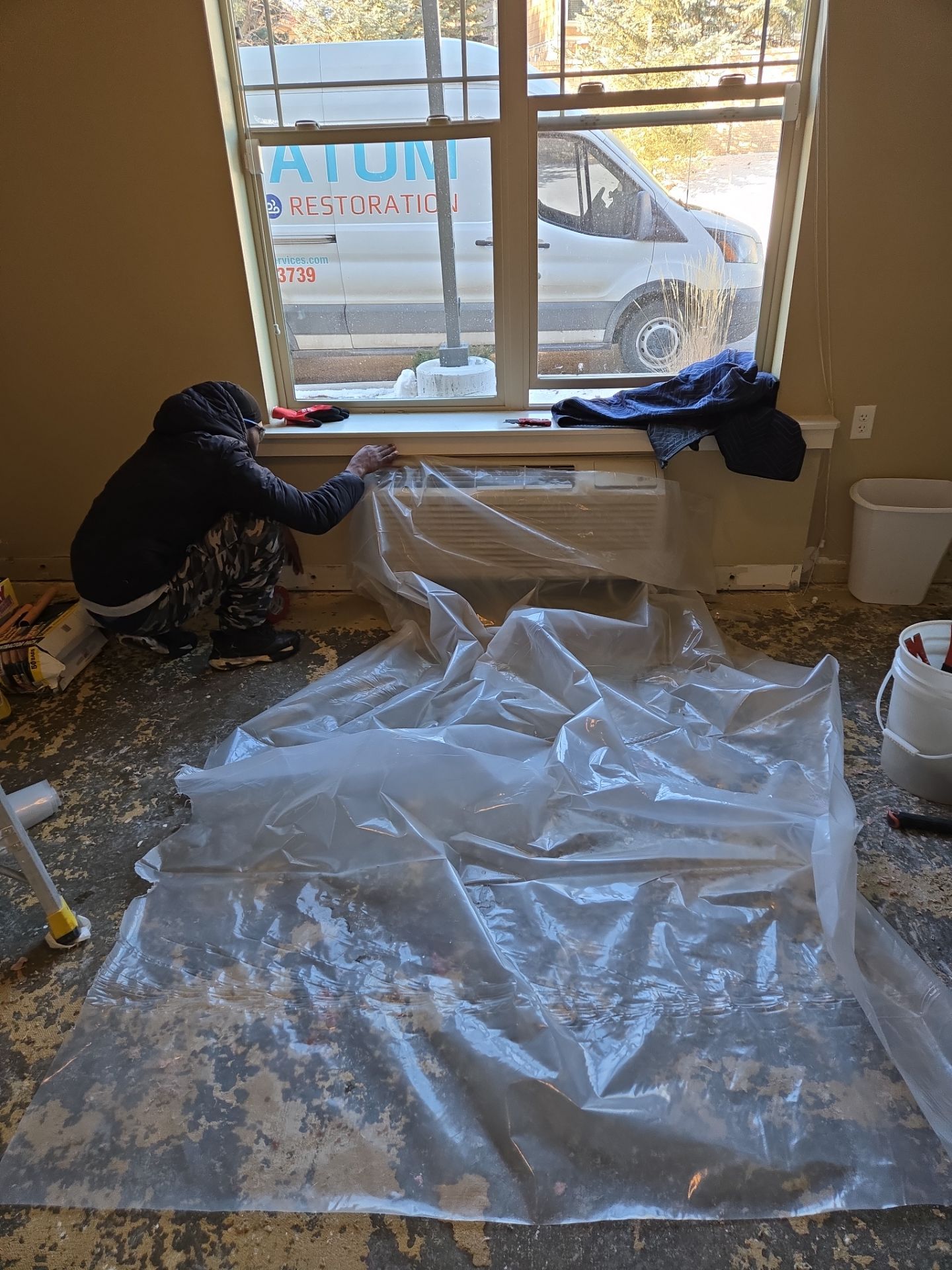 Worker setting up plastic sheeting