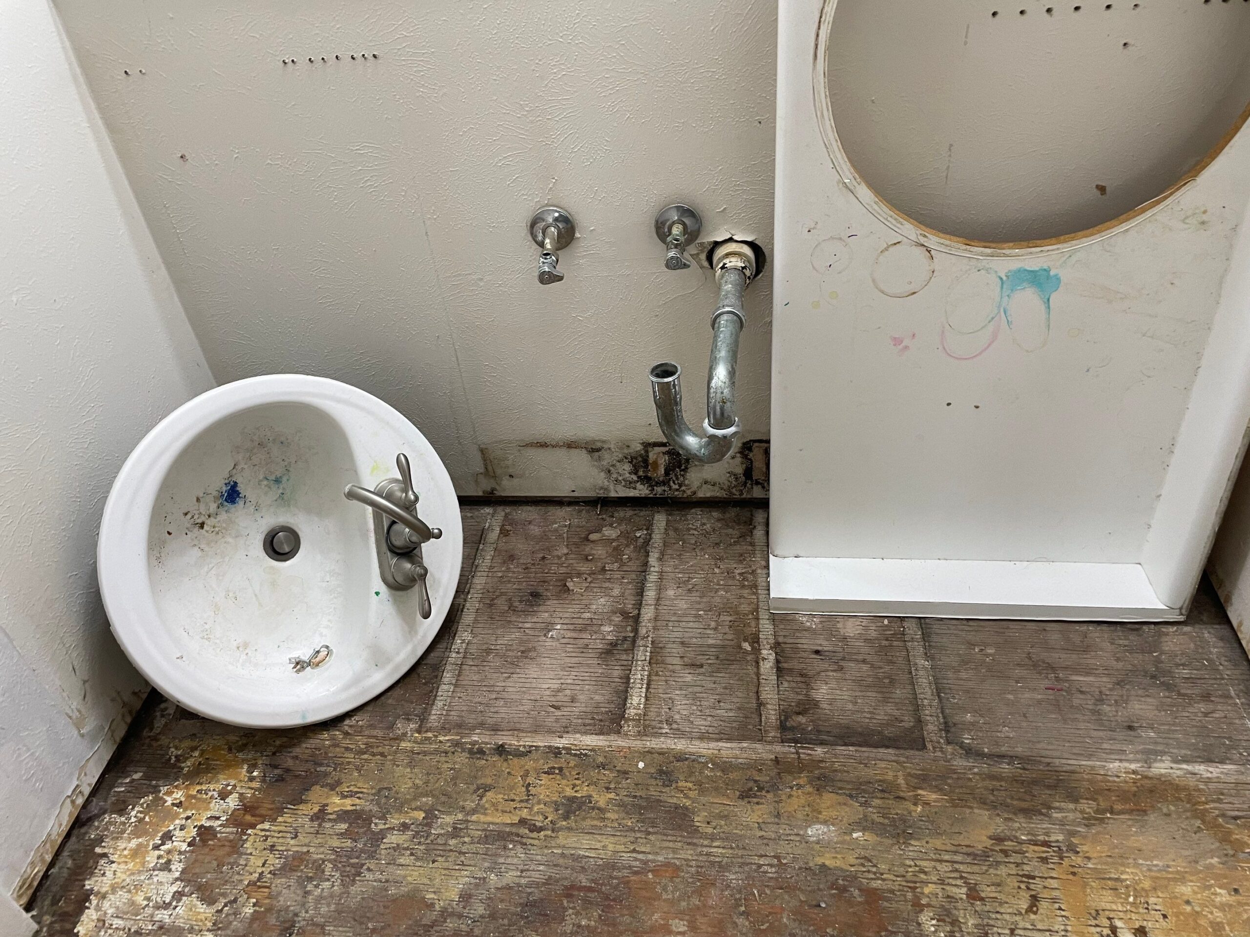 Removed sink with water damage on the wall