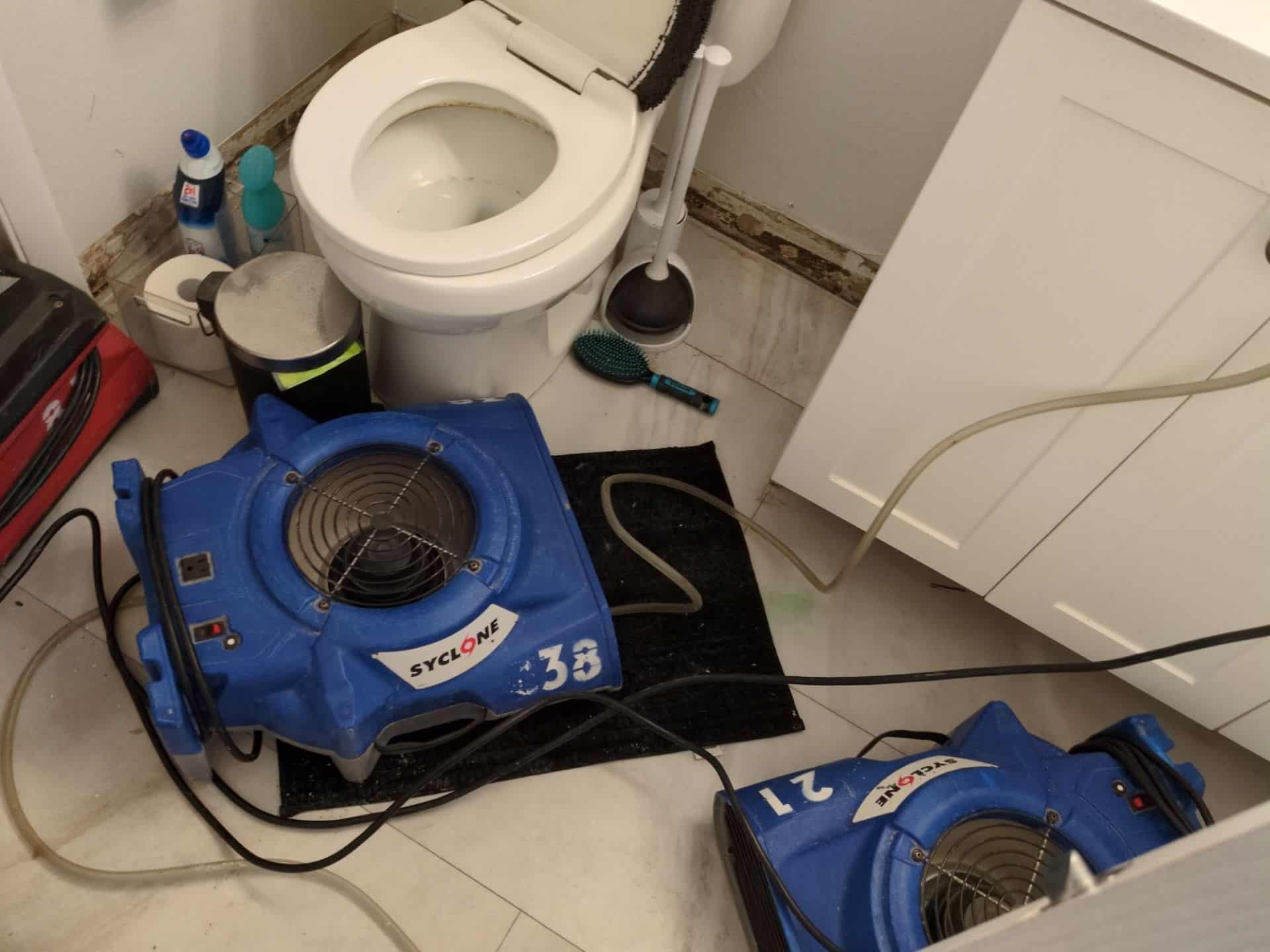 Air movers drying a water-damaged bathroom