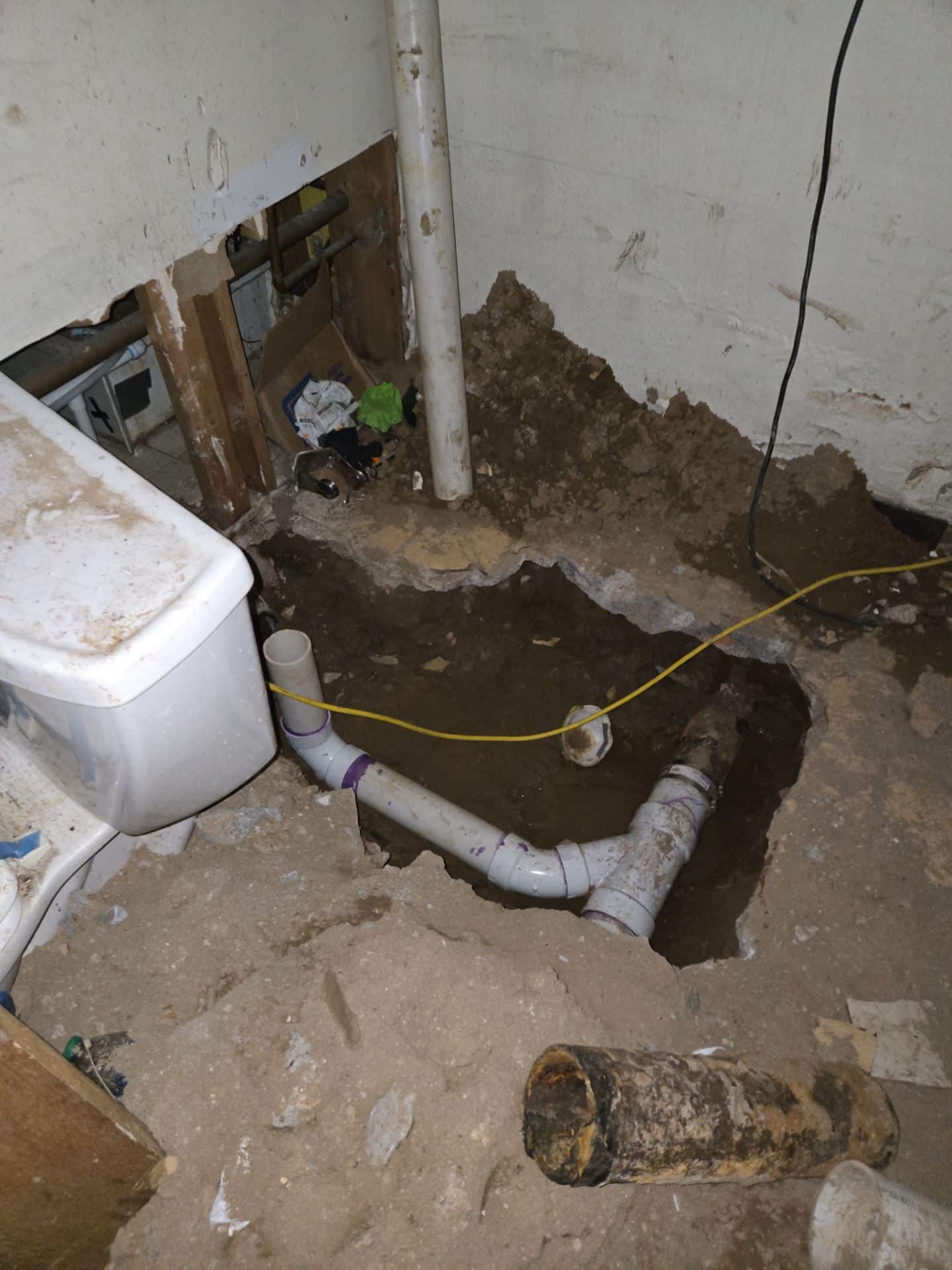 Large hole in the floor exposing pipes