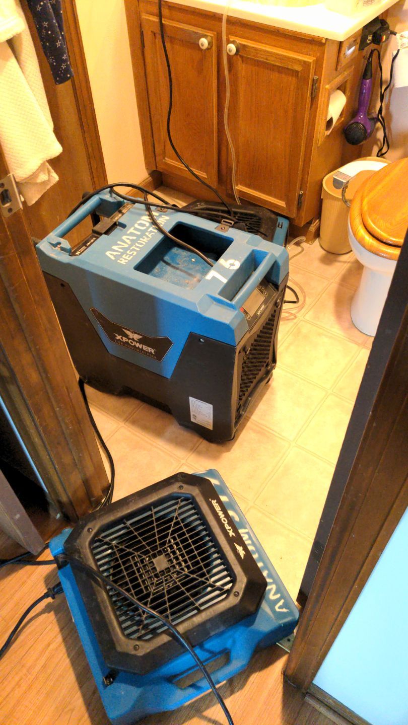 Water damage restoration machines in small bathroom