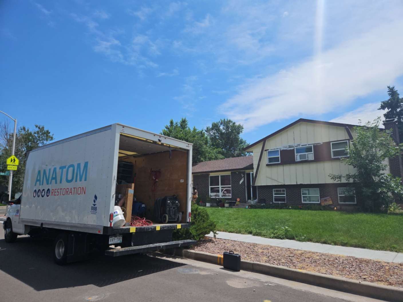 Anatom Restoration truck parked outside a residential home