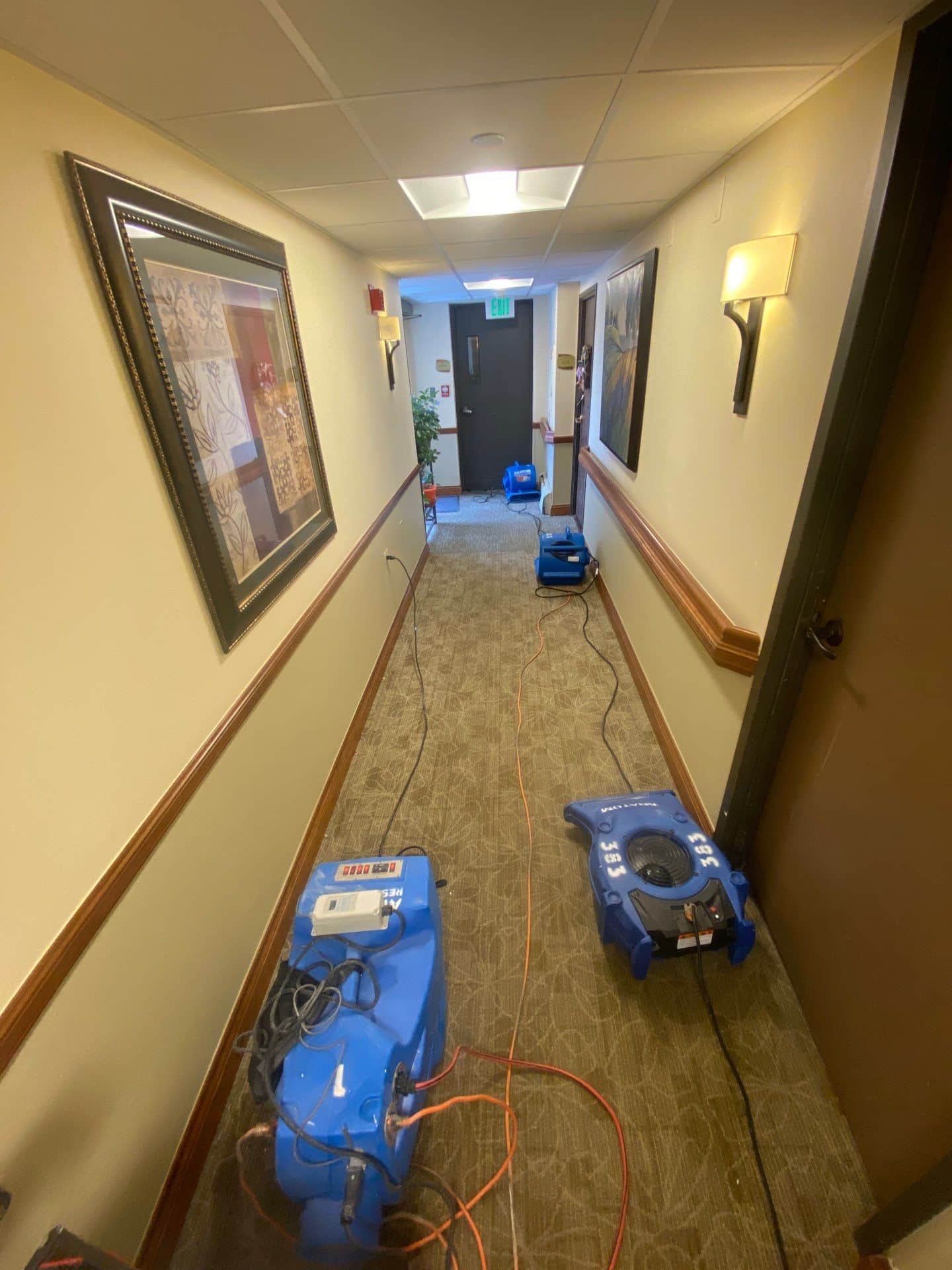Commercial hallway with drying equipment set up after water damage.