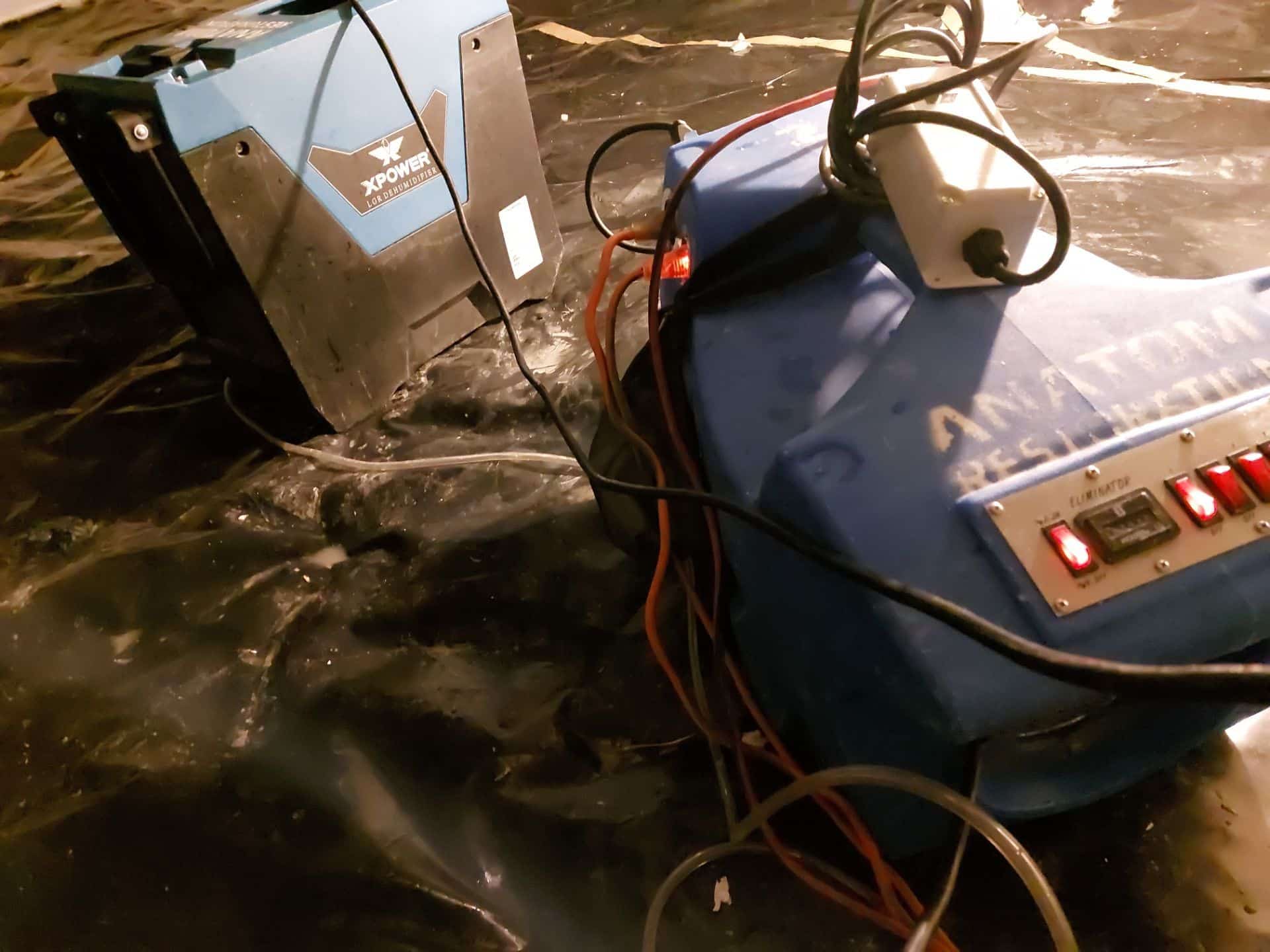 Restoration equipment set up in a crawl space for drying and dehumidification.