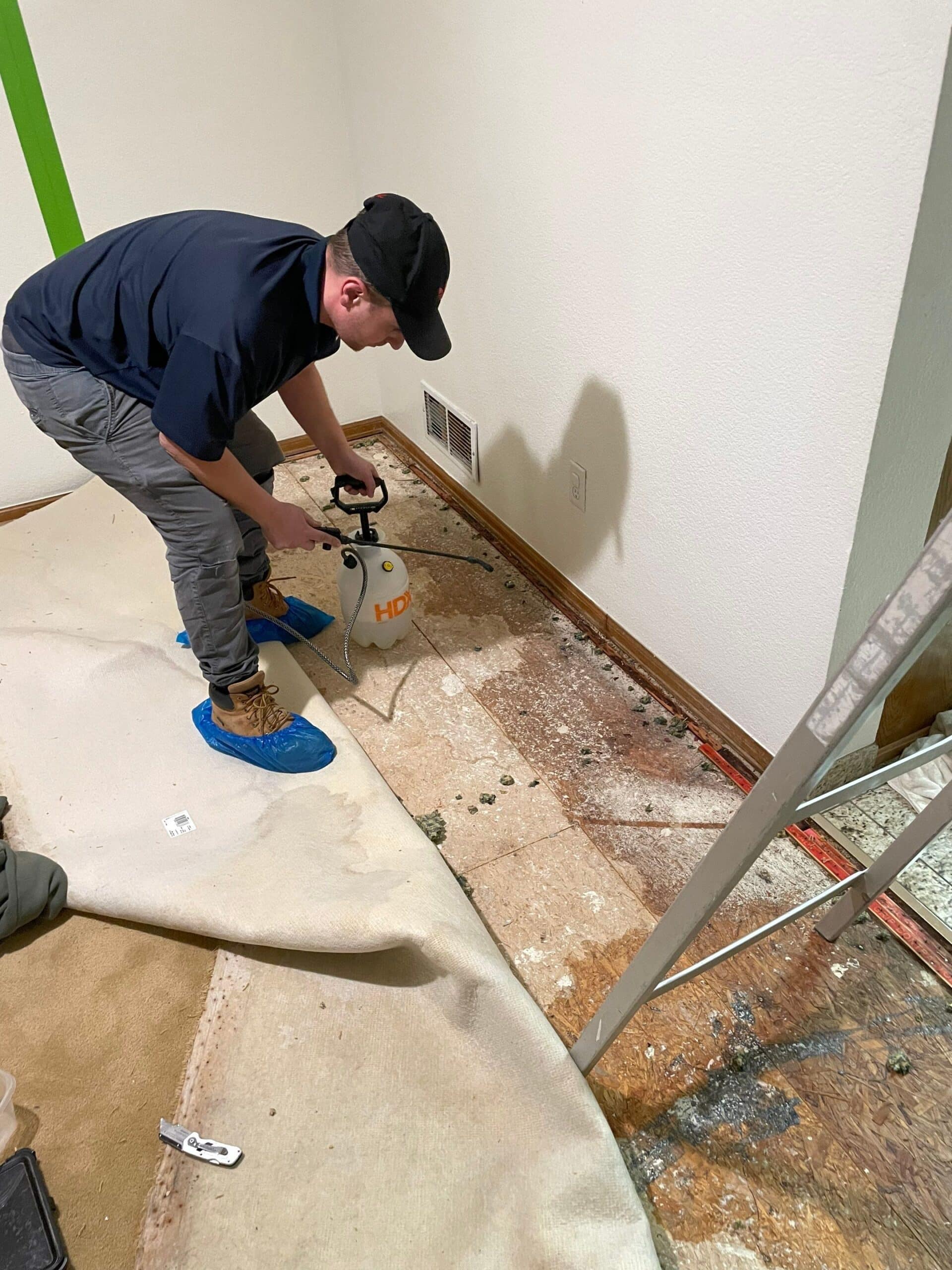 Technician applying treatment to a water-damaged floor.