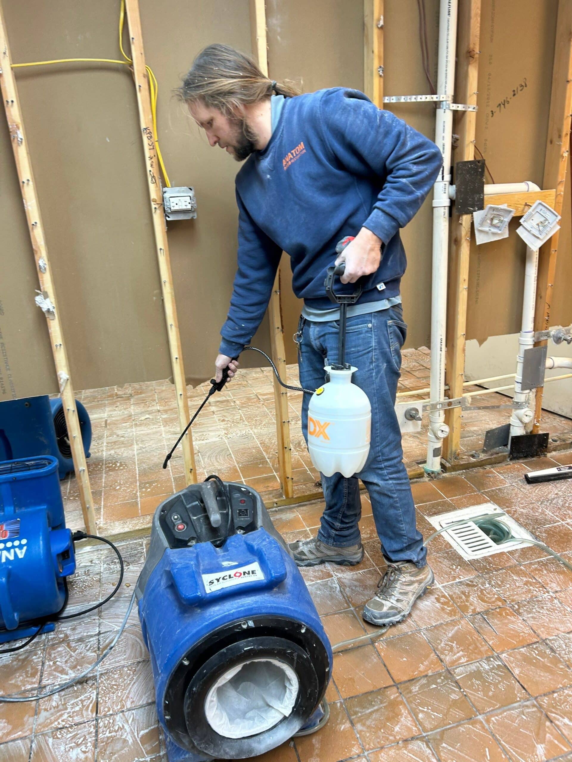 Worker spraying near air scrubber