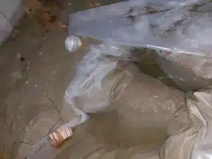A flooded area is shown with ductwork wrapped in a protective material, partially submerged in water