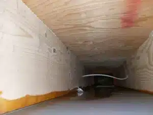 A water-damaged wooden structure with standing water inside