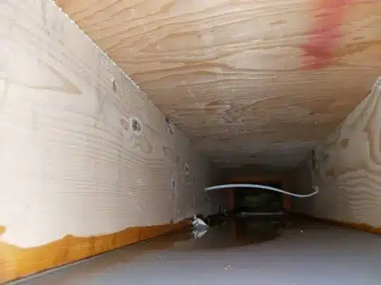 A water-damaged wooden structure with standing water inside