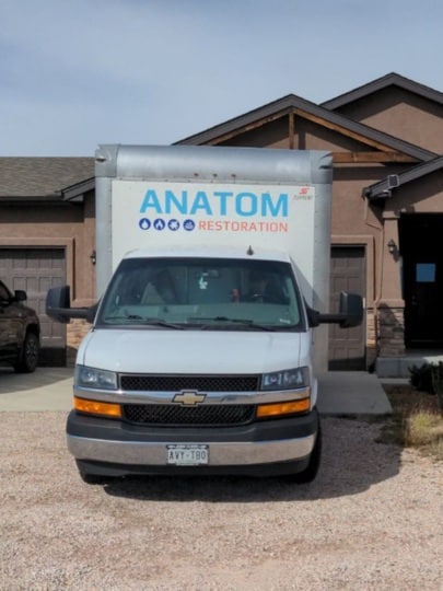 Anatom Restoration truck in front of a house
