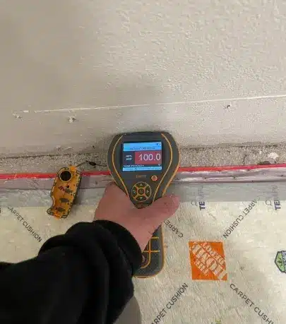 Dan, our Lead Mitigation Technician, using a digital moisture meter to assess water damage at a restoration site