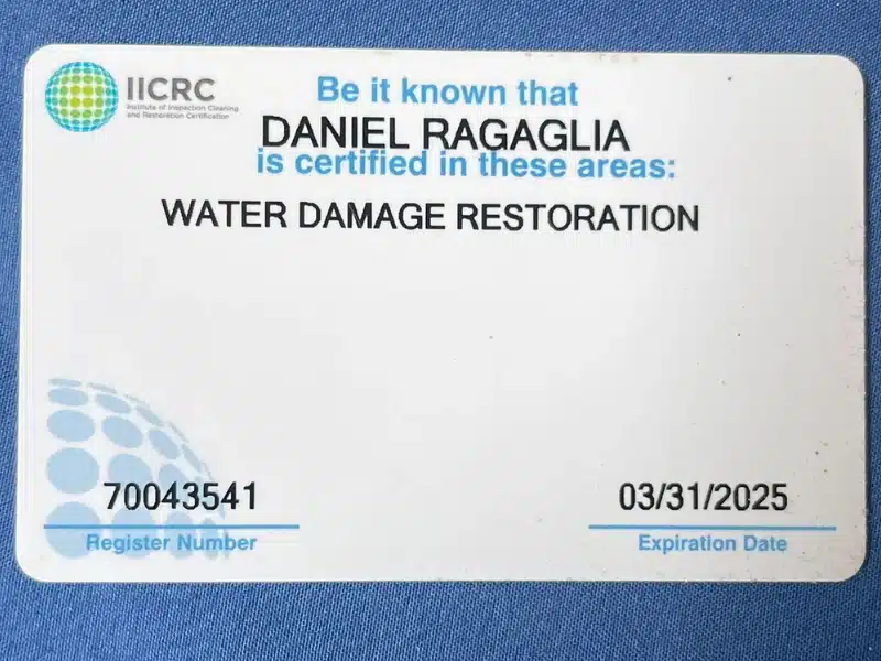 A certification card showing water damage restoration credentials for a professional, issued by the IICRC. The card includes a register number and expiration date.